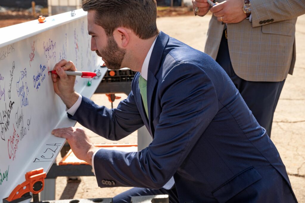 Representative Houston Gaines signs the final beam of the new Athens Technical College industrial systems technology building before it is placed after the Topping Out Ceremony.