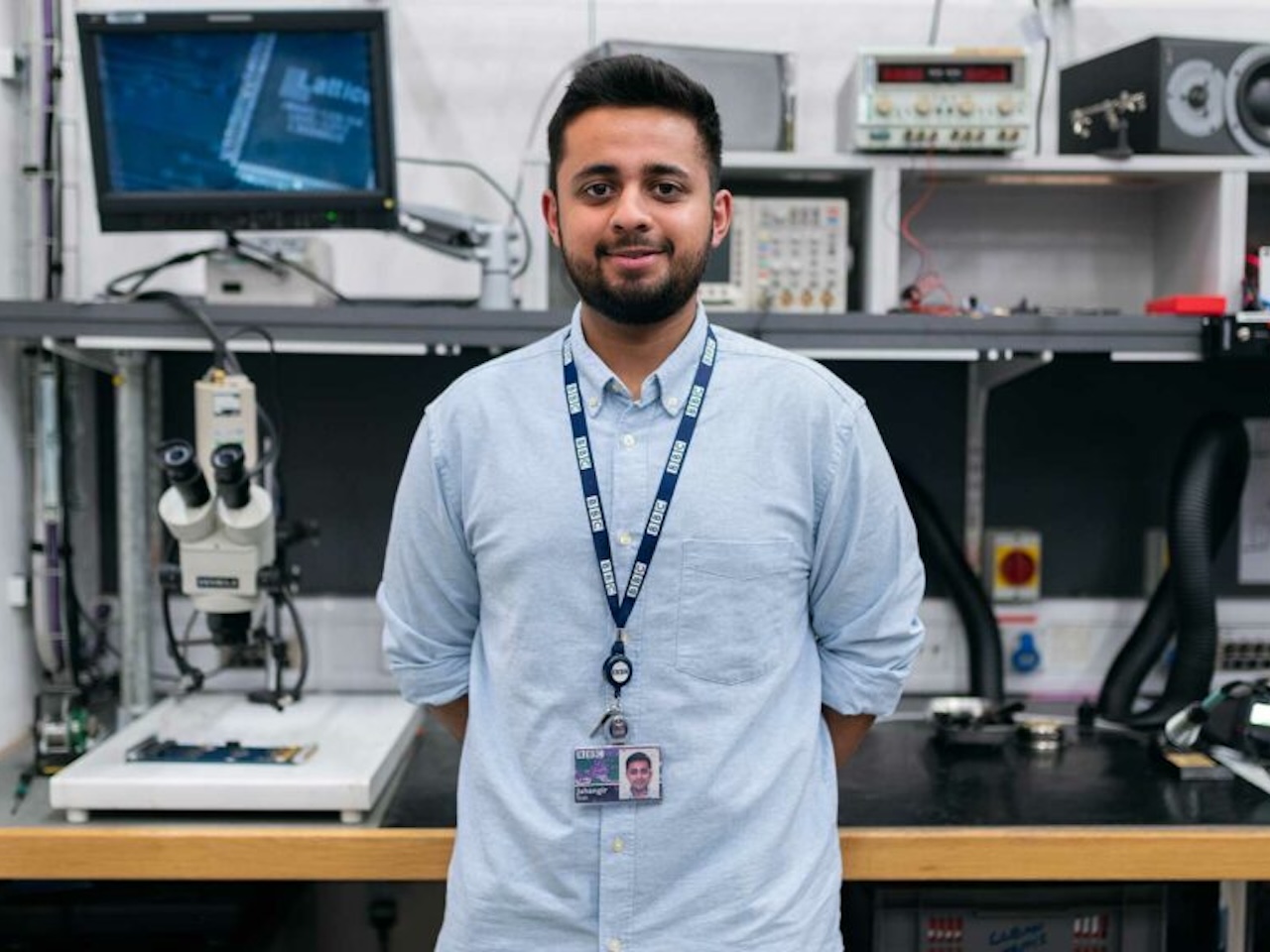 Student standing in front of computers/work station