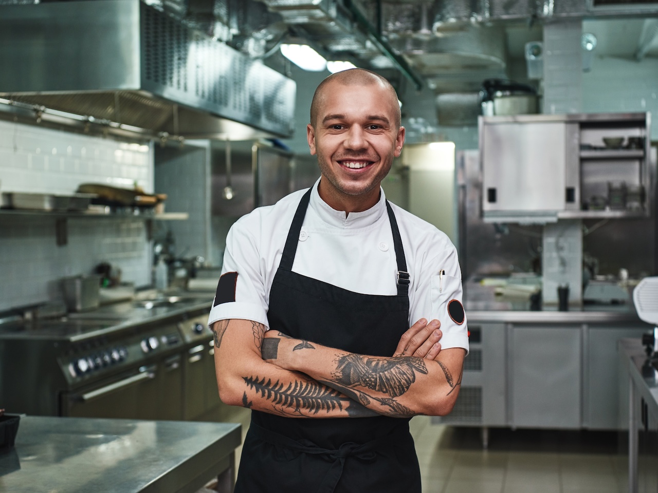 Person standing in an industrial kitchen in an apron