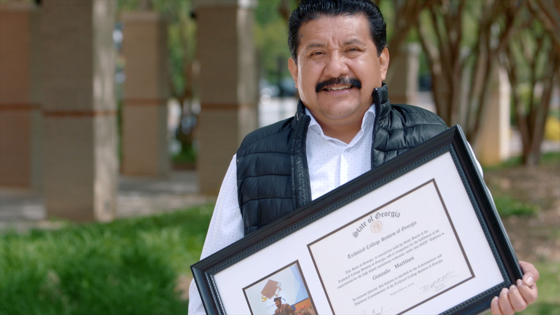 Adult education graduate holding their degree